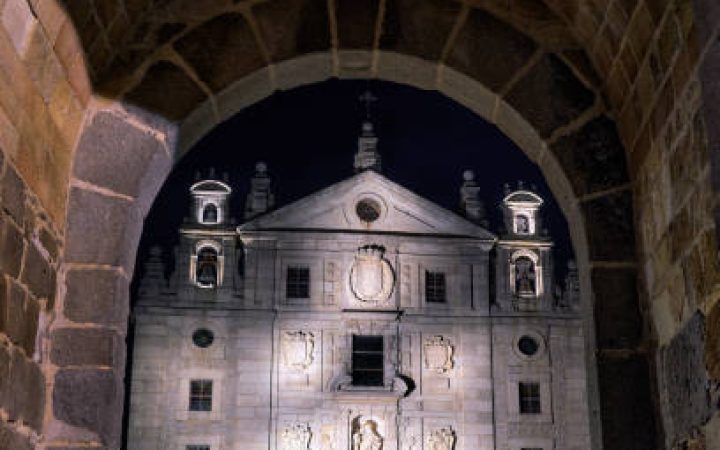 Santa Teresa church view through gate of the walls at night in Avila, Spain